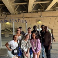 Group of students posing near pew station